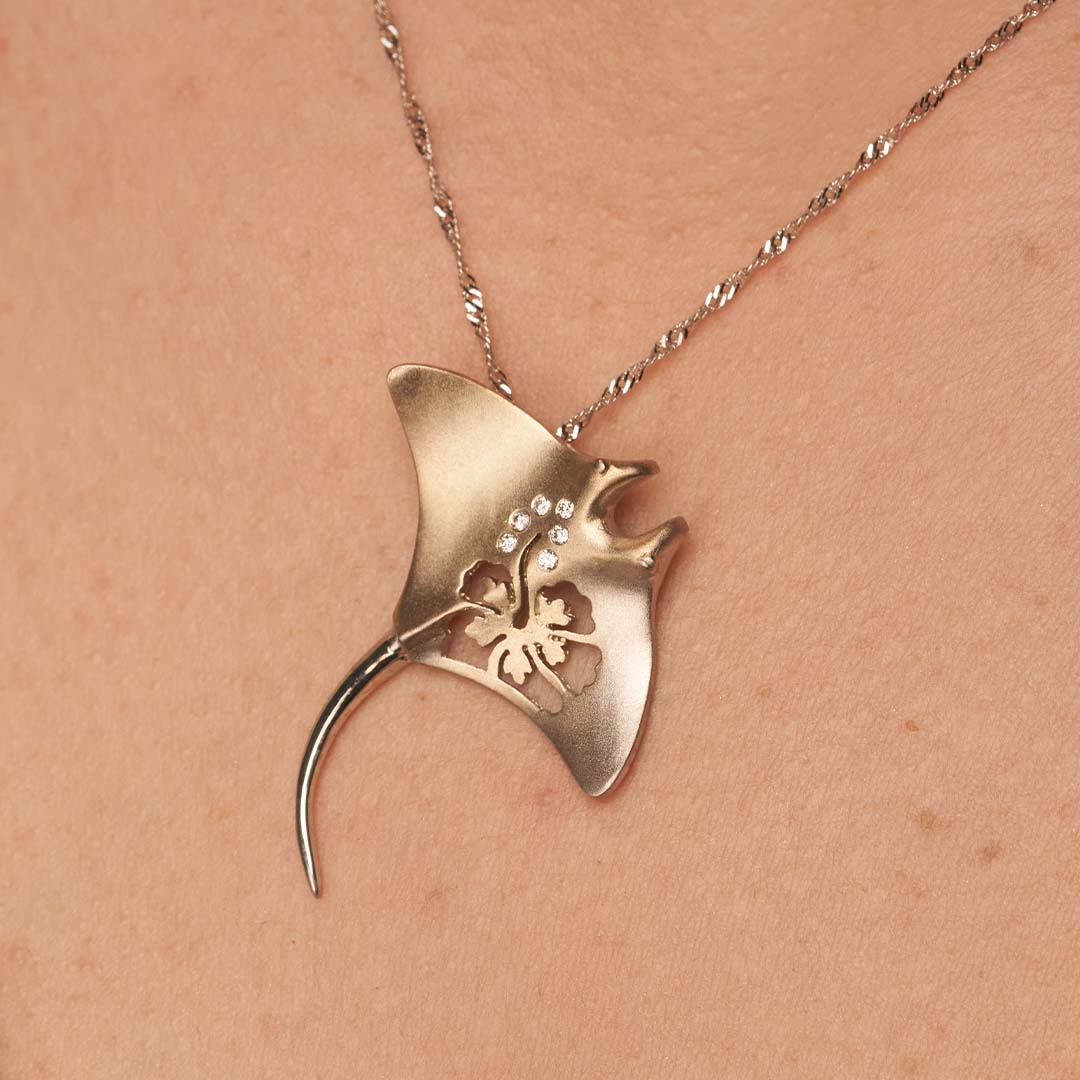 Woman Wearing a Yellow Gold Manta Ray with Hibiscus Cutout and Diamond Accents by Park City Jewelers