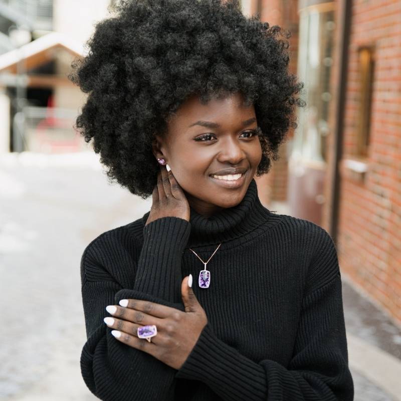 Woman wearing amethyst rings, necklace, and earrings - Park City Jewelers.