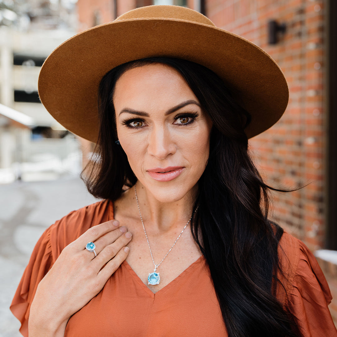 Woman wearing Park City Jewelers blue topaz ring and necklace