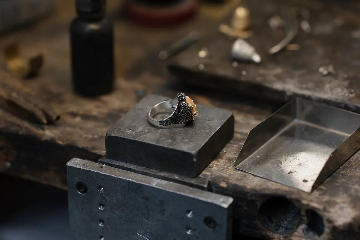Sterling Silver and 14K Gold Elk Ivory Ring on a Jewelers Bench by Park City Jewelers