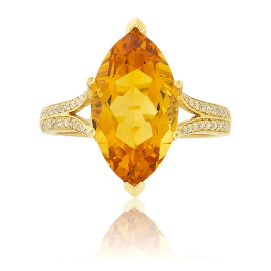 Top-down view of a large, marquise-cut golden citrine ring with a pavé diamond split shank band in 14K yellow gold.