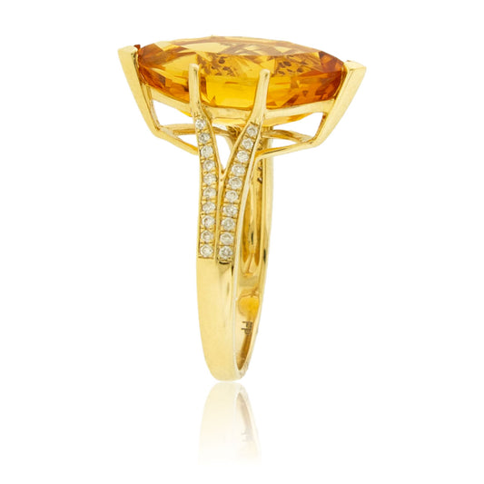 Angled view of a marquise citrine ring, showing the diamond-paved split shank and the architectural gallery of the 14K yellow gold setting.