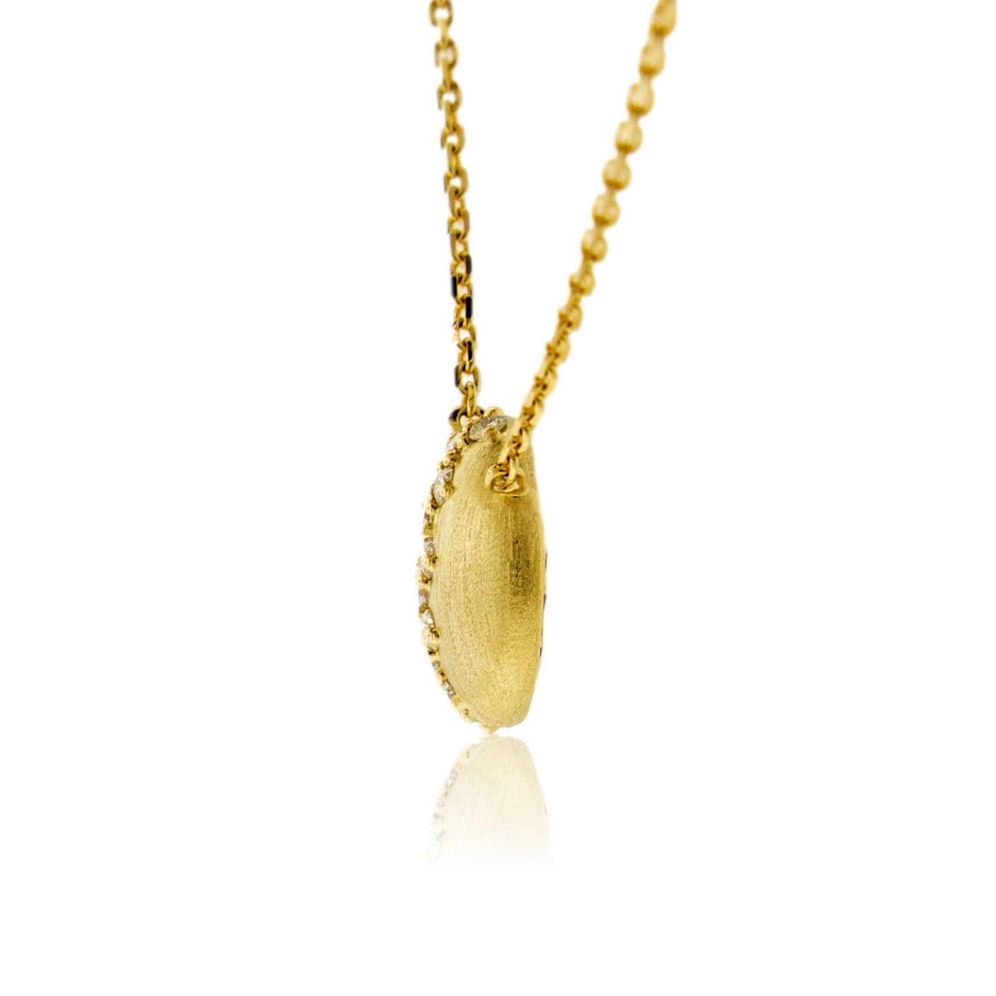 A side profile view of the satin-finished 14K gold domed diamond pendant, showing its thickness and the diamonds set along the curve.
