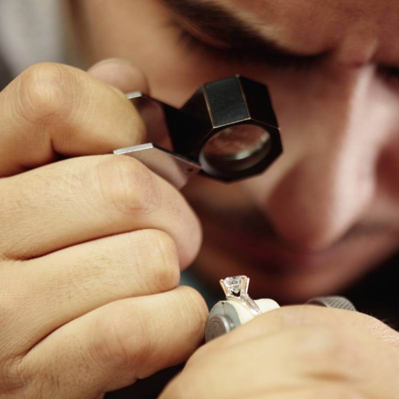 Jeweler inspecting diamond ring with loop