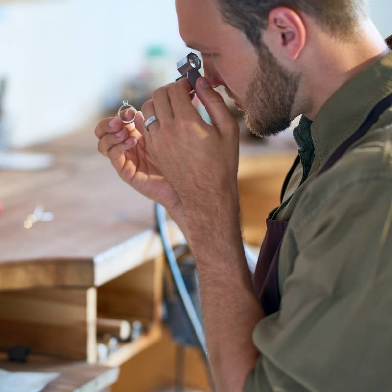 Jeweler looking at ring through loop