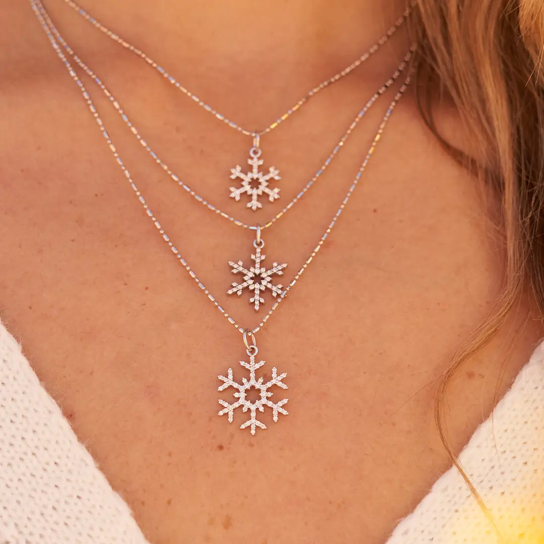 Woman Wearing Three White Gold and Diamond Snowflakes from Park City Jewelers.
