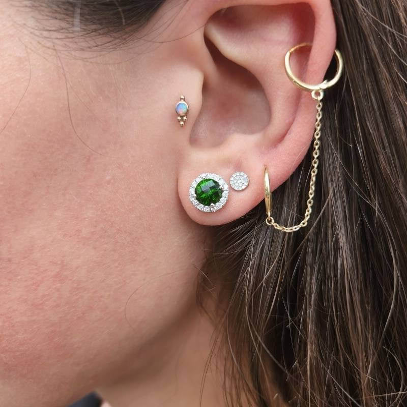 Woman wearing tsavorite garnet diamond halo earrings