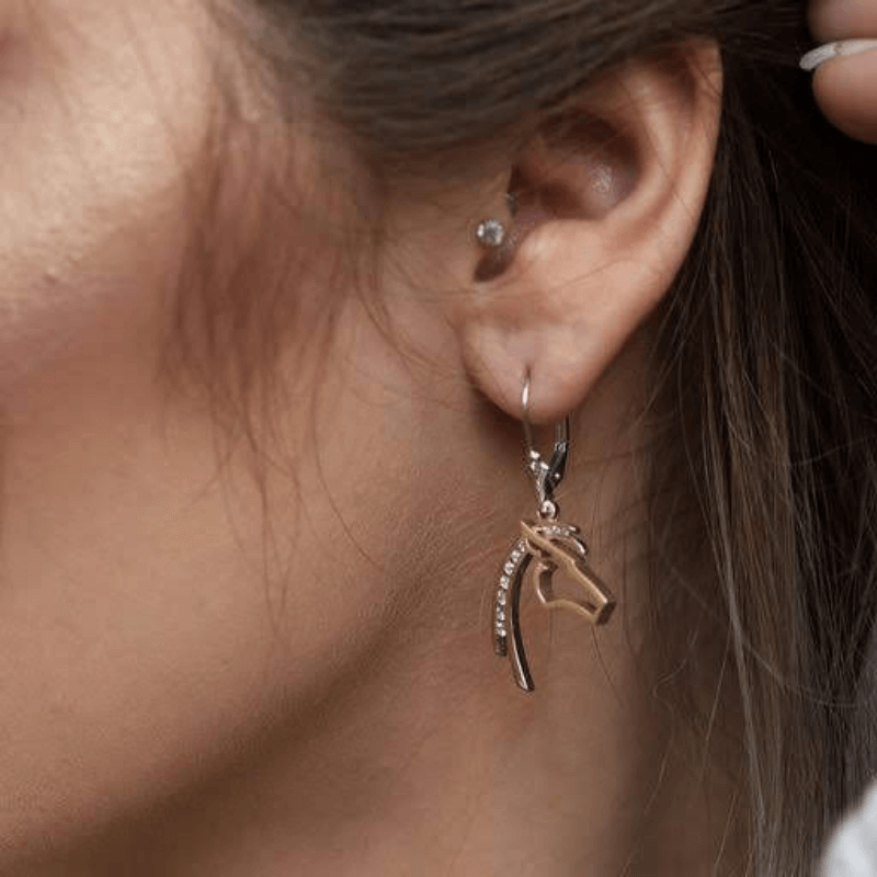 Woman wearing Park City Jewelers diamond lined horse earrings