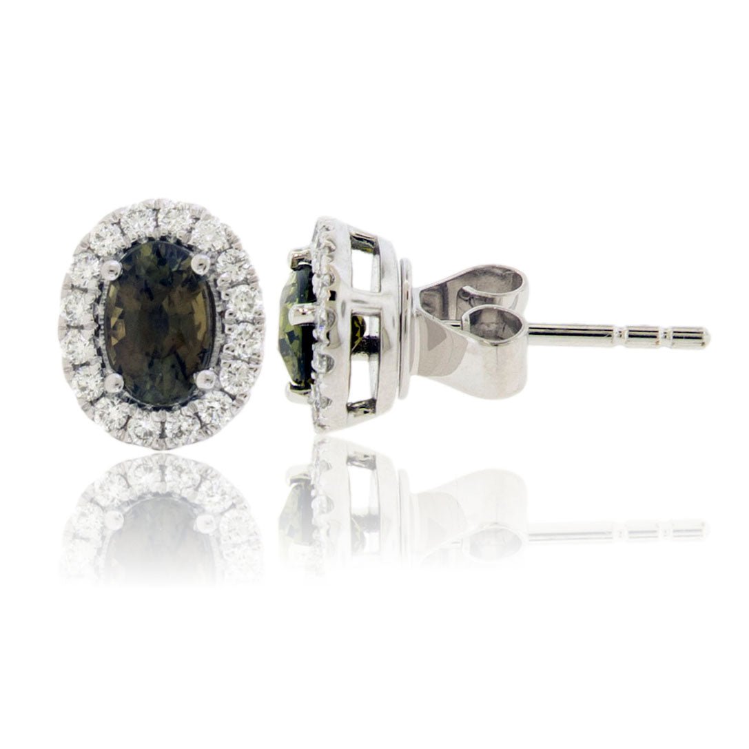 Front and side profile view of an oval alexandrite and diamond halo stud earring, showing the basket setting and post in 14K white gold.