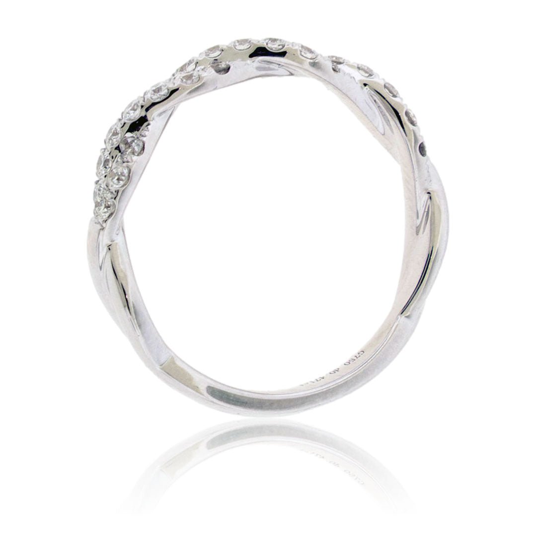 Angled side profile of a diamond twist ring in white gold, showing the interwoven design of the pavé-set and polished metal bands.