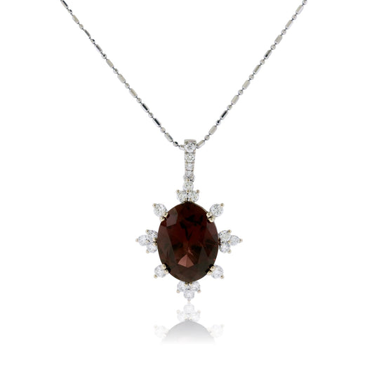 A large, oval Raspberry Garnet pendant in 14K white gold, surrounded by a starburst-style halo of prominent round diamonds.