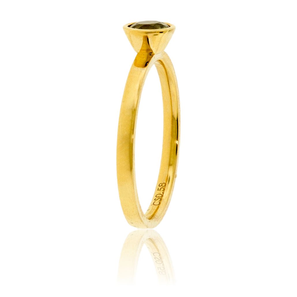 Edge-on view of the alexandrite ring, highlighting the soft satin finish of the 14K yellow gold band and the profile of the bezel setting.