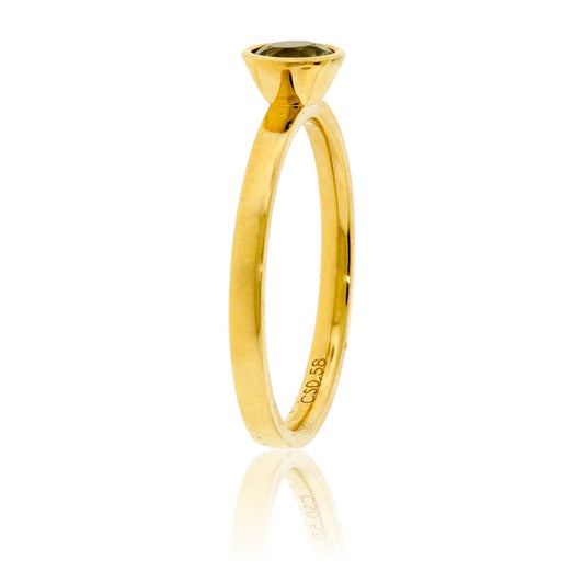 Edge-on view of the alexandrite ring, highlighting the soft satin finish of the 14K yellow gold band and the profile of the bezel setting.