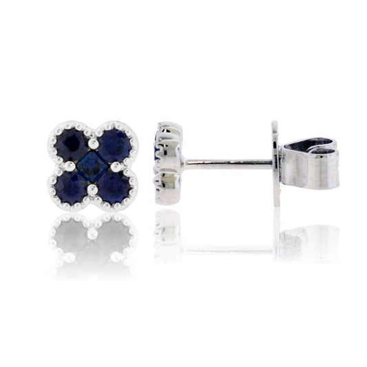 Front and side profile view of a sapphire clover stud earring, showing the milgrain detail, the 18K white gold setting, and the post back.