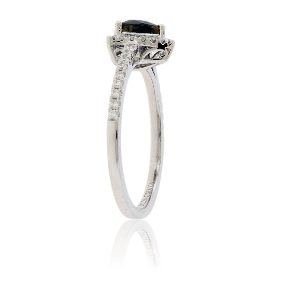 A 14K white gold ring featuring a trillion-cut alexandrite with a brownish-green color, surrounded by a diamond halo on a delicate, pavé-set diamond band side view.