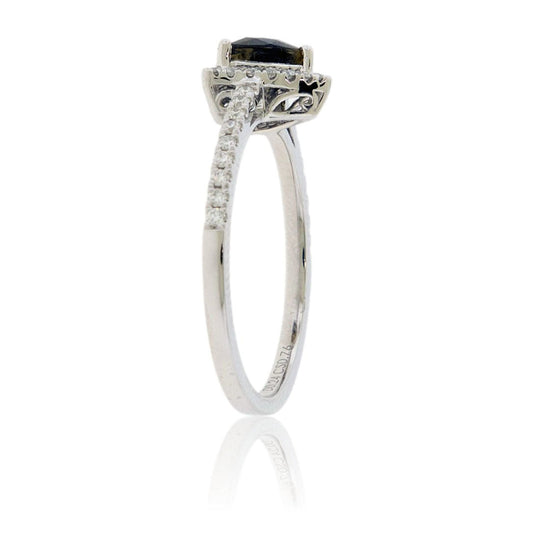 A 14K white gold ring featuring a trillion-cut alexandrite with a brownish-green color, surrounded by a diamond halo on a delicate, pavé-set diamond band side view.