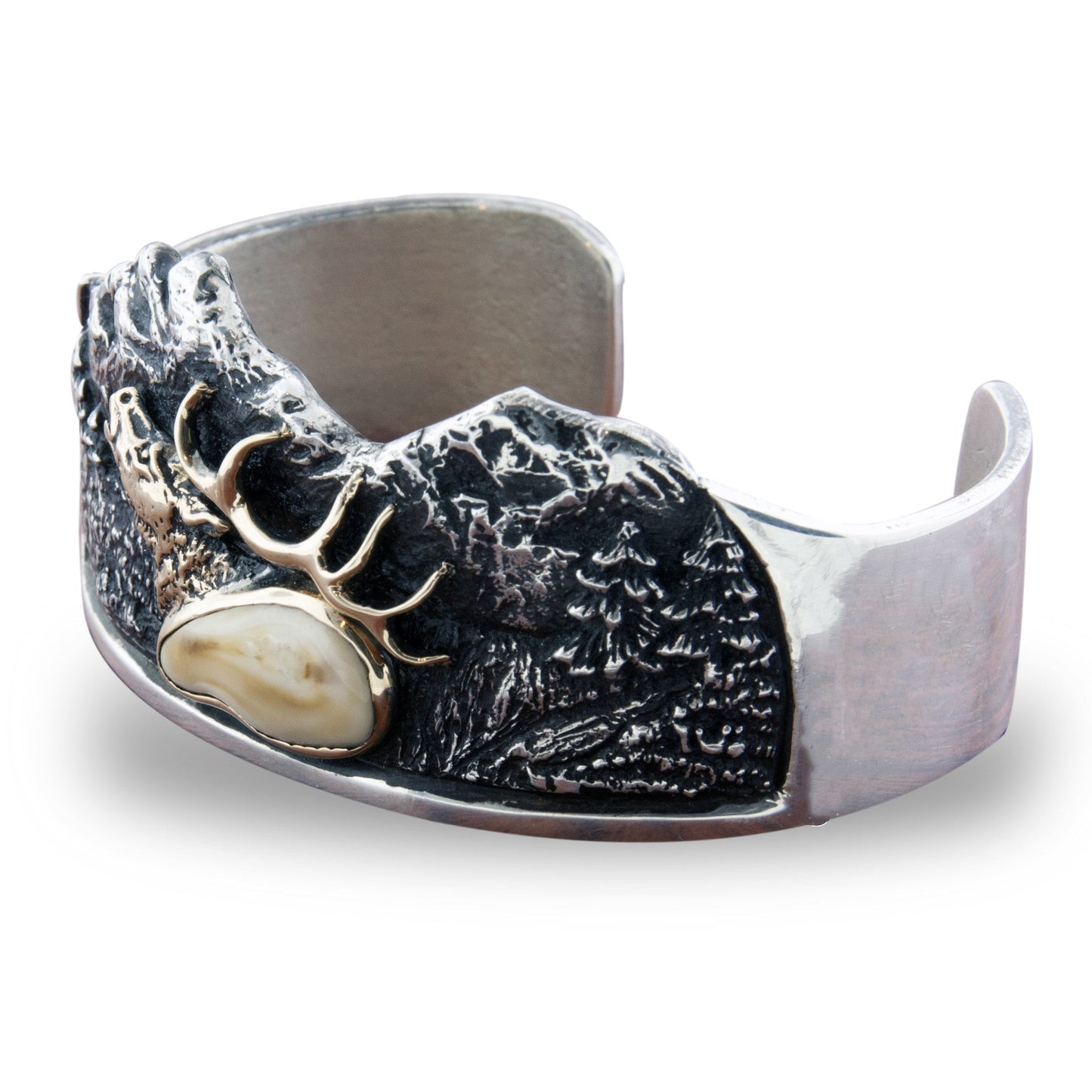 Angled view of the mountain scene cuff bracelet, showing the depth and texture of the hand-carved silver mountains and gold elk.