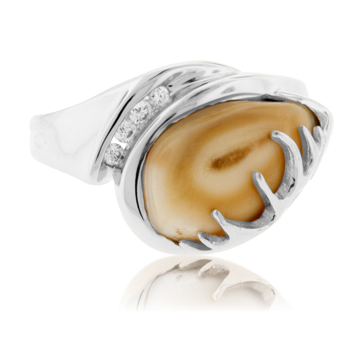 An asymmetrical elk ivory ring in 14K white gold, featuring a sculptural antler and a channel of four diamonds.