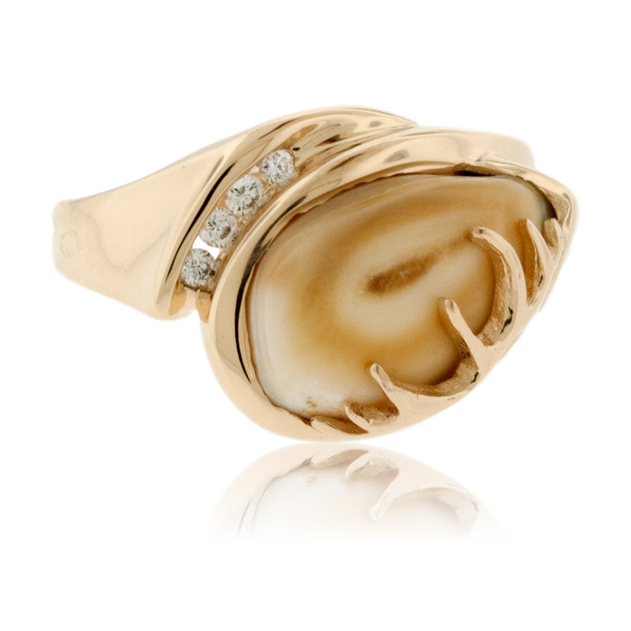 An asymmetrical elk ivory ring in 14K yellow gold, with a sculptural antler on one side and four channel-set diamonds on the other.