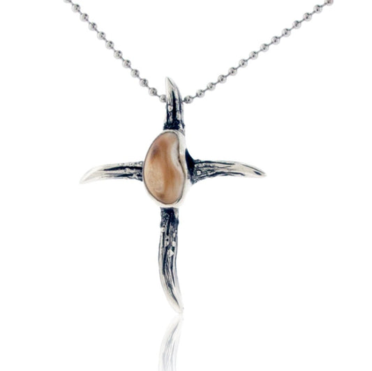 A sterling silver cross pendant, formed from four textured elk antlers, with a polished, bezel-set elk ivory at the center.
