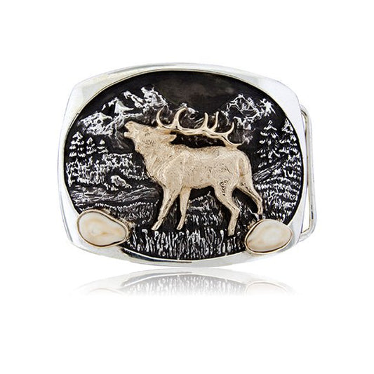 A sterling silver trophy belt buckle with a detailed mountain scene, featuring a 14K yellow gold bugling elk in the center and two bezel-set elk ivories.