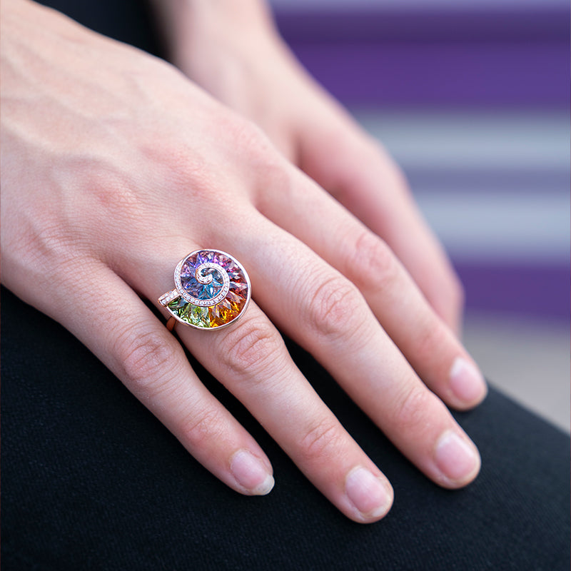 Stunning woman showcasing Bellarri's Ammonite Pendant, a blend of vibrant gemstones set in rose gold, exemplifying luxury and elegance.