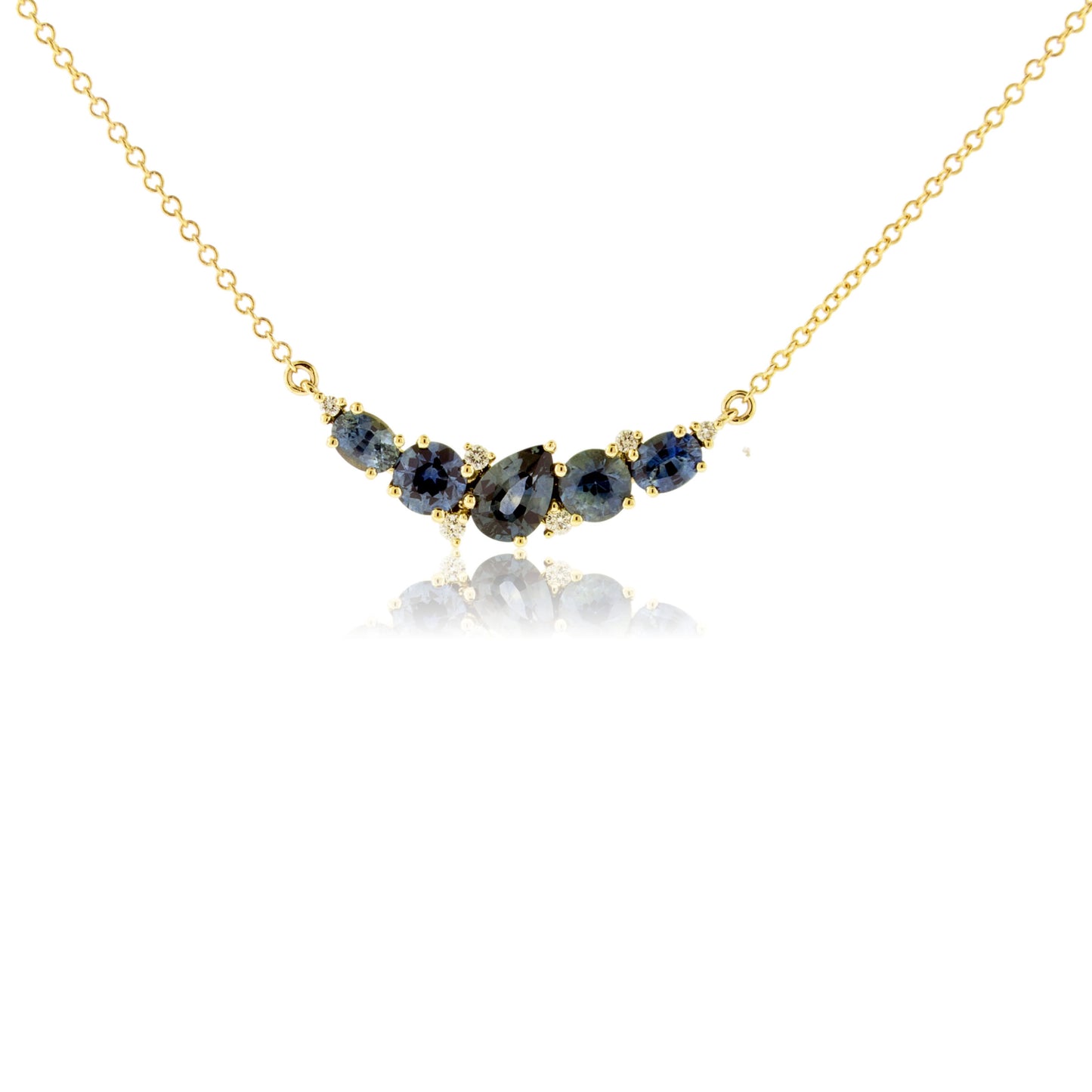 Montana sapphire cluster line necklace in 14K yellow gold with five teal-blue pear, round, and oval sapphires and diamond accents on a cable chain