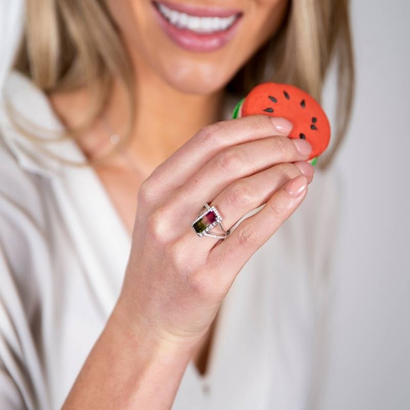 Woman wearing watermelon tourmaline ring while holding watermelon macaroon 