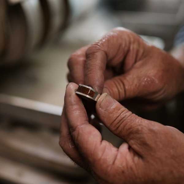 Jeweler Holding Freshly Polished Dinosaur Bone Ring - Park City Jewelers. 