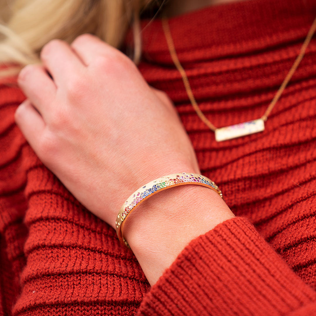 Woman wearing gold and rainbow sapphire confetti bracelet and necklace