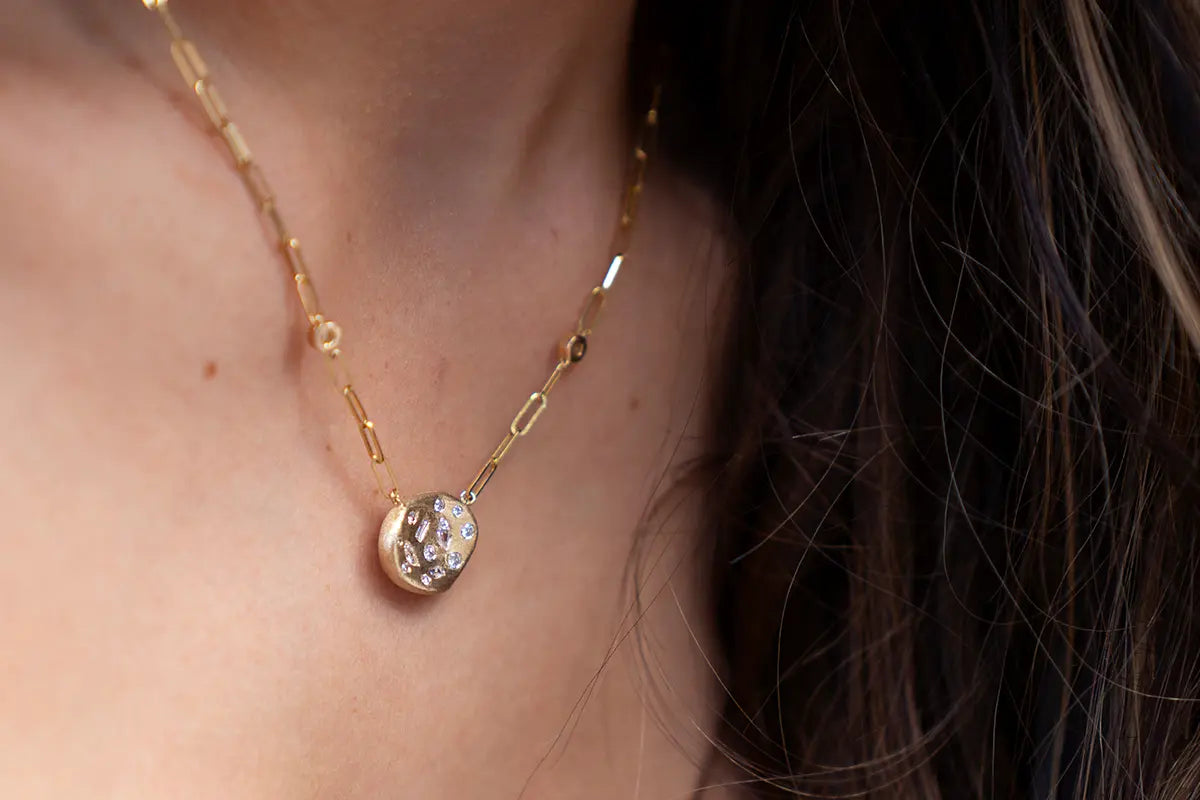 Woman Wearing a Gold Confetti Pendant with Paperclip Chain from Park City Jewelers