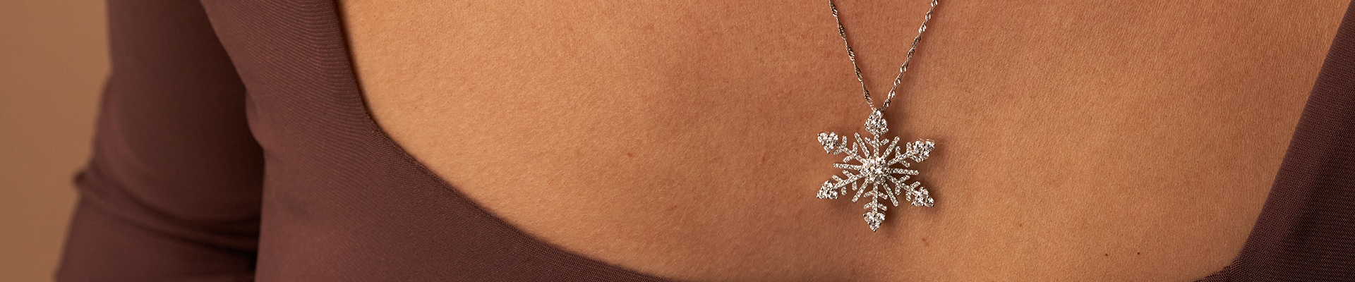 Woman wearing 14K white gold diamond snowflake pendant from Park City Jewelers