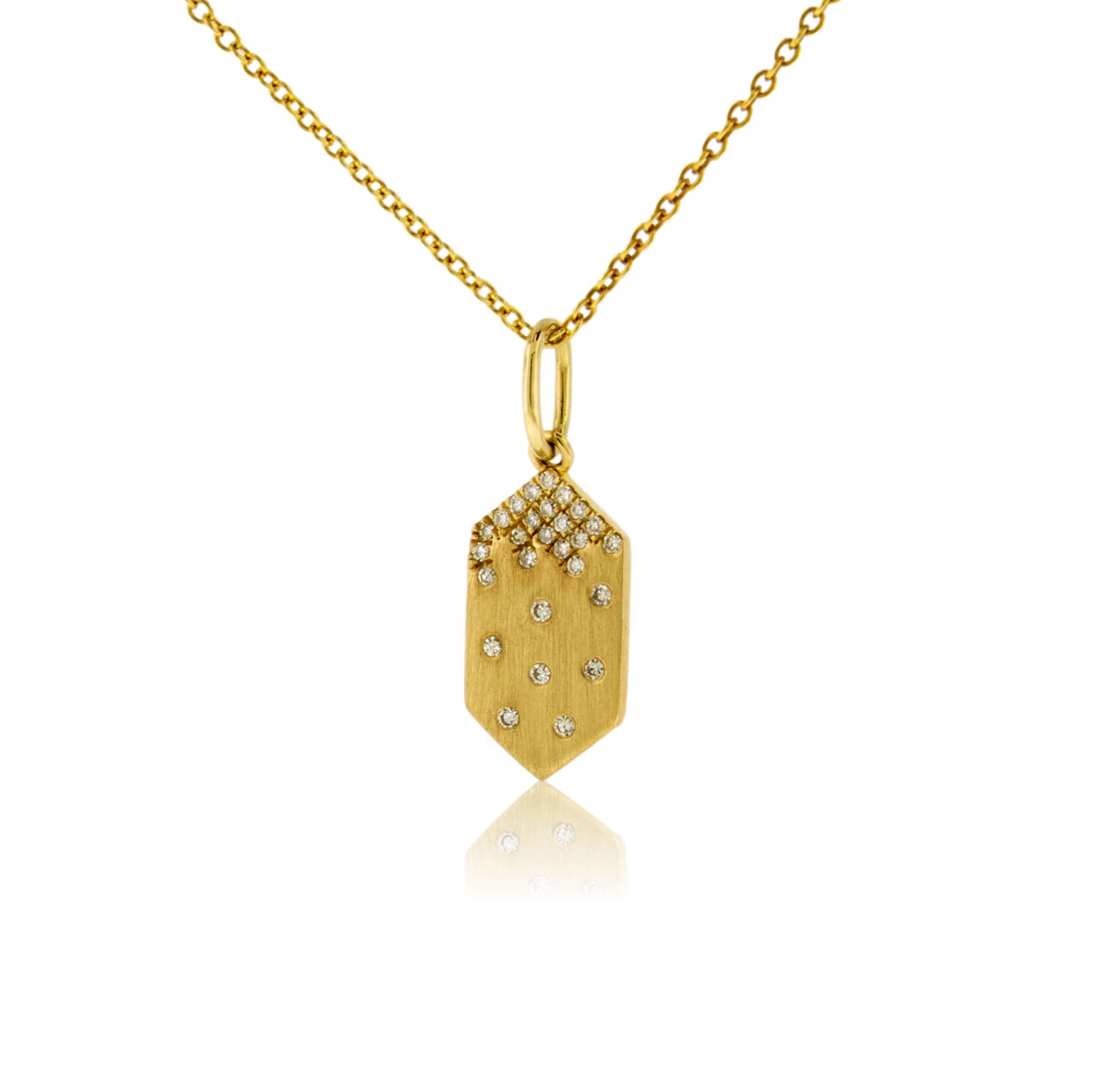 A 14K yellow gold geometric tag-shaped pendant with a satin finish, featuring a cluster of pave diamonds at the top and scattered flush-set diamonds below, shown on a gold chain.
