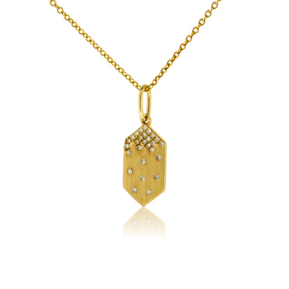 A 14K yellow gold geometric tag-shaped pendant with a satin finish, featuring a cluster of pave diamonds at the top and scattered flush-set diamonds below, shown on a gold chain.