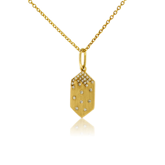 A 14K yellow gold geometric tag-shaped pendant with a satin finish, featuring a cluster of pave diamonds at the top and scattered flush-set diamonds below, shown on a gold chain.