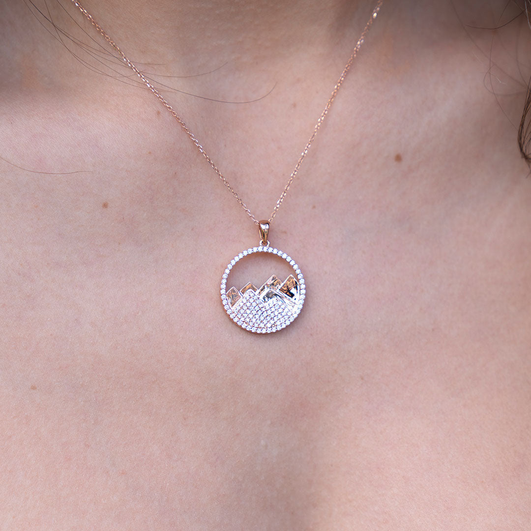 Woman wearing gold and diamond circle mountain necklace