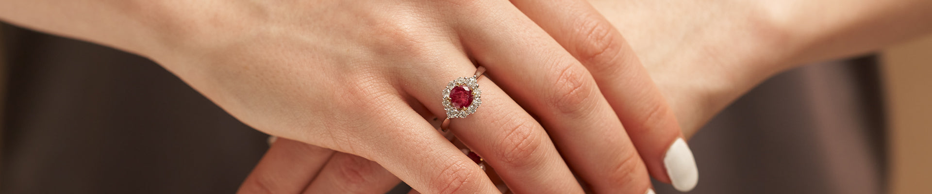 Woman Wearing Red Emerald and Diamond Halo Ring from Park City Jewelers