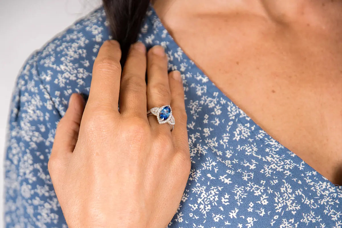 Woman Wearing Marquise Sapphire ring with Diamond Halo from Park City Jewelers