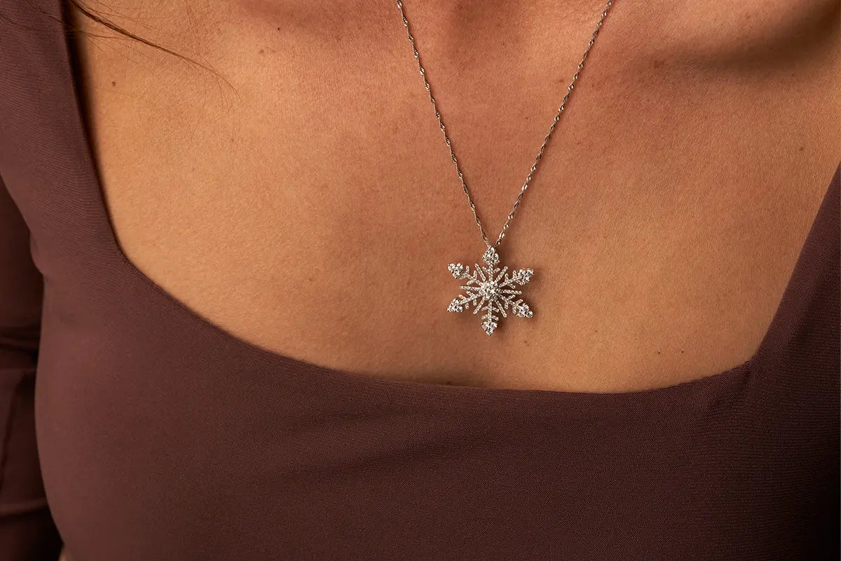 Woman Wearing White Gold and Diamond Snowflake Pendant from Park City Jewelers