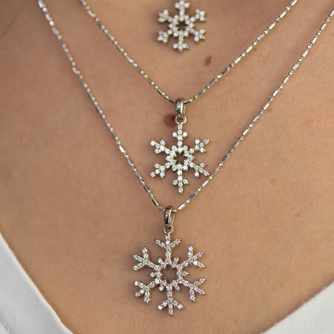 Woman wearing three Park City Jewelers snowflake pendants