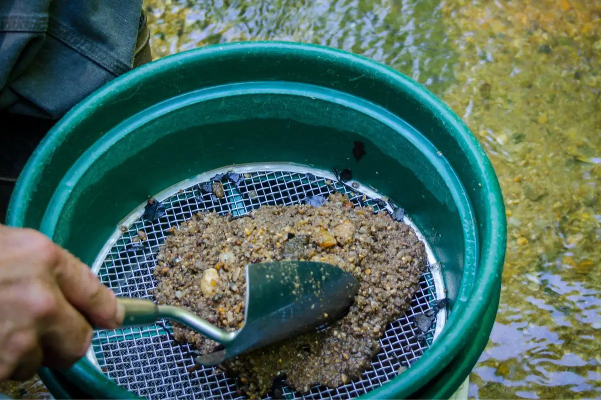 Man sifting Dirt Through a Screen