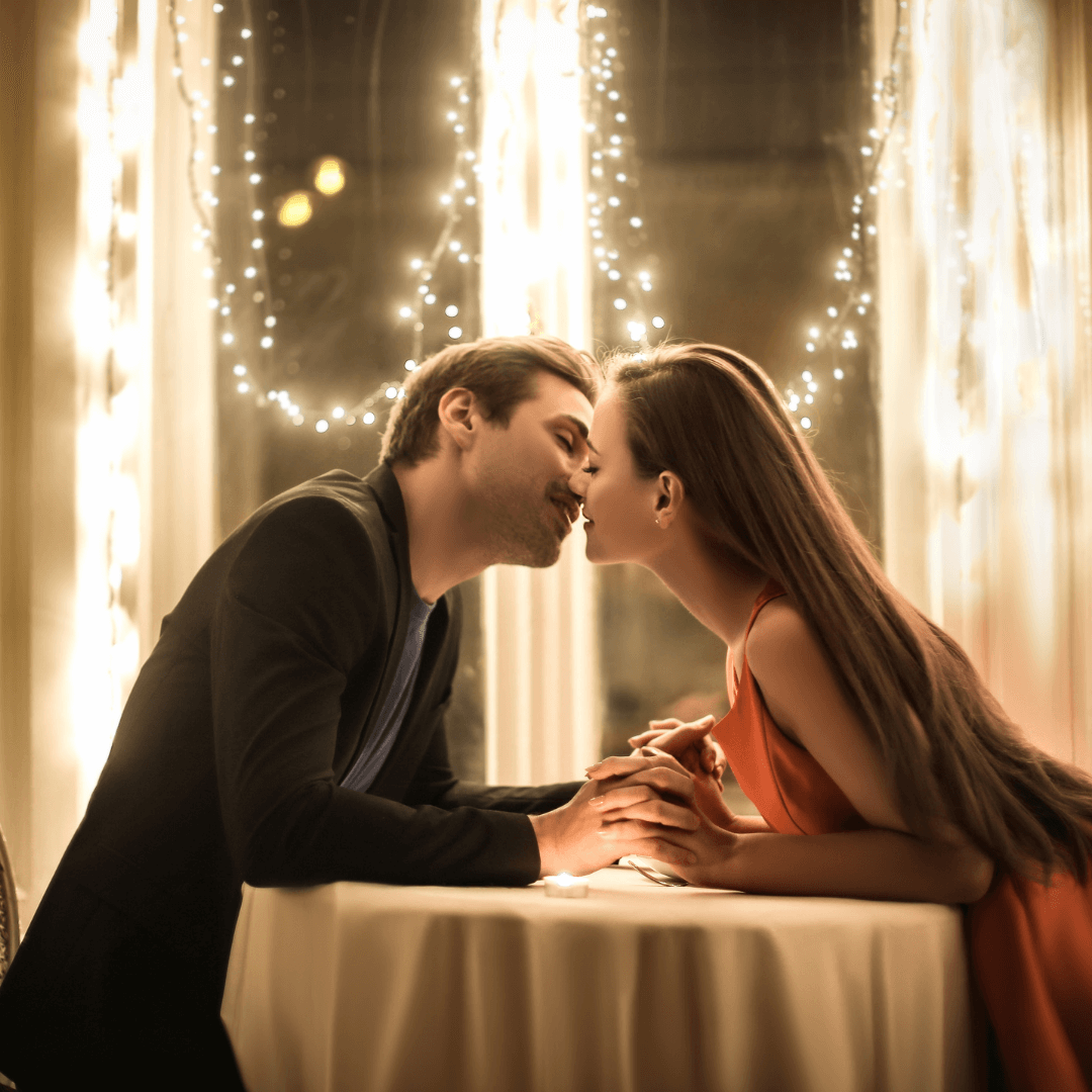 Couple kissing over a table