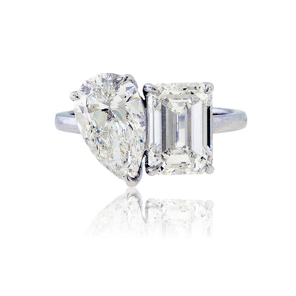 Front view of a 14K white gold ring featuring a pear-shaped and emerald-cut lab-grown diamond set side by side.