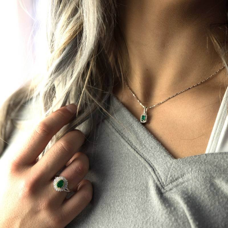 Woman wearing emerald ring and necklace