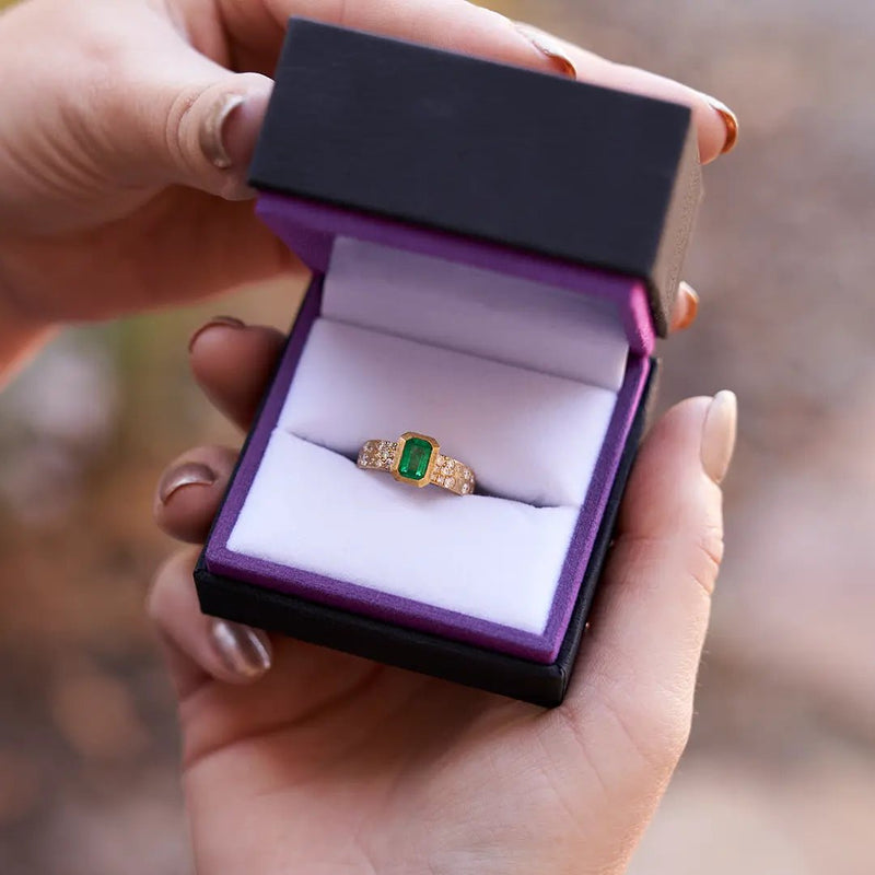 Bezel Set Emerald - Cut Emerald in Yellow Gold with Flush Set Diamond Band - Park City Jewelers