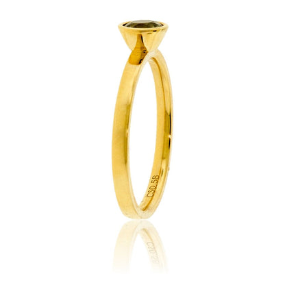 Edge-on view of the alexandrite ring, highlighting the soft satin finish of the 14K yellow gold band and the profile of the bezel setting.