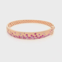 video of rose gold bangle bracelet with scattered rubies and sapphires
