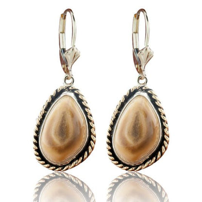 A pair of two-tone dangle earrings featuring polished elk ivories, each framed with a braided 14K yellow gold halo in a sterling silver setting.